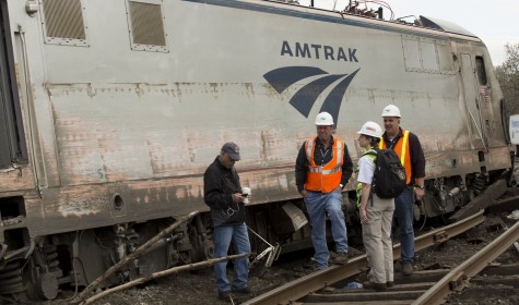 Investigators inspect the derailed train. It was later determined that the train was traveling two times faster than the recommended speed for the area of track it was on.