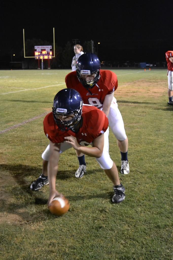 Football+players+practice+receiving+on+the+sidelines.