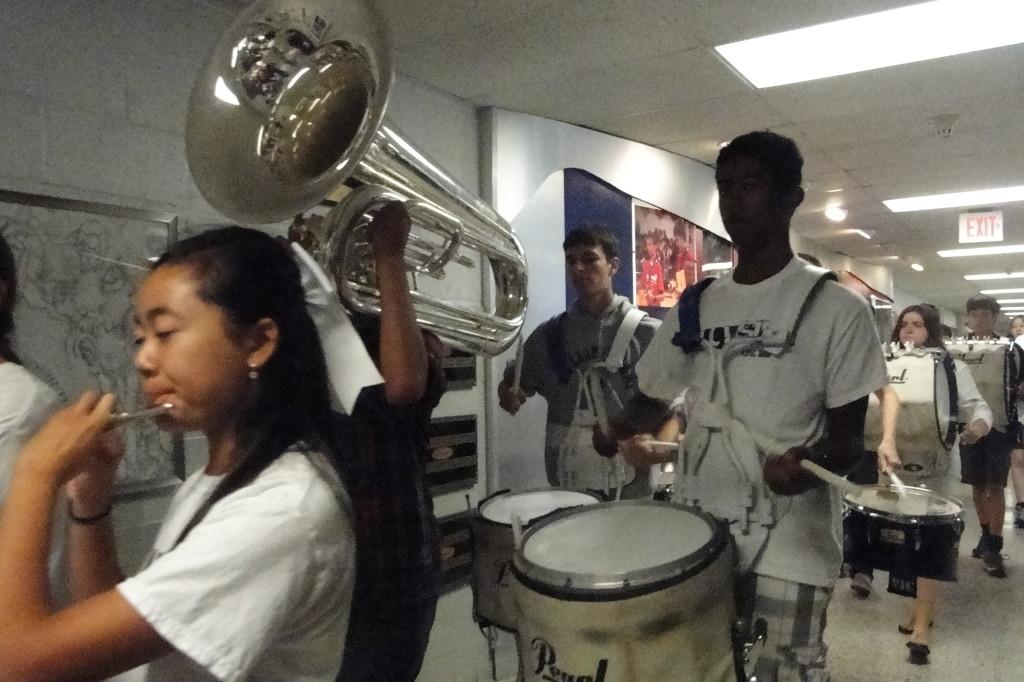 Students play their instruments in the main hallway