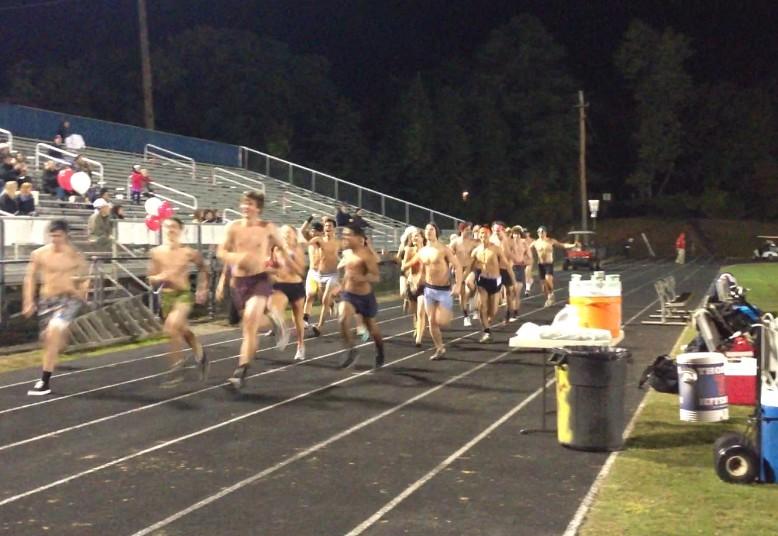 Seniors run down the track in boxers and sports bras in honor of senior streak.