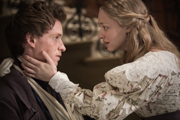 Cosette (Amanda Seyfried) embraces Marius (Eddie Redmayne) after the attack at the barricade in the Les Misérables film.