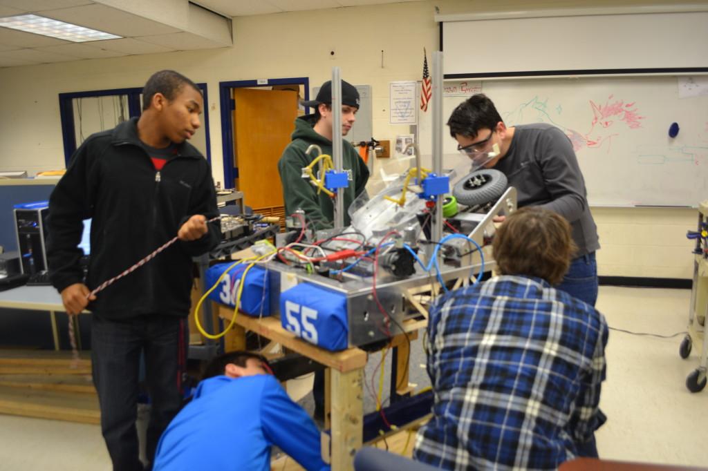 Members of the FIRST Robotics team work on putting the finishing touches on their robot. 