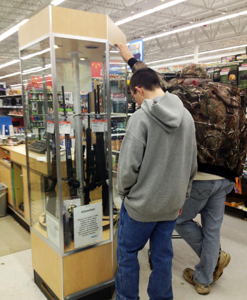 A father and son look at the rifle case at a Wal-Mart in Warrenton.