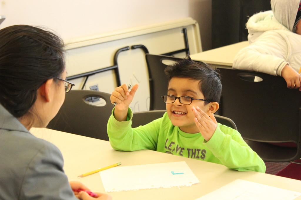 Kindergartener+Mutahar+Baig+of+Springfield+Estates+Elementary+School+converses+with+Lake+Braddock+senior+Marisa+Paipongna.