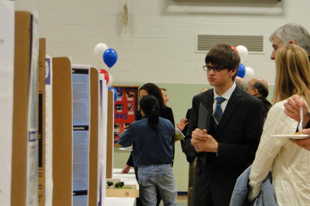 Senior+Alec+Brenner+browses+through+the+various+mentorship+projects+presented+at+the+fair.+