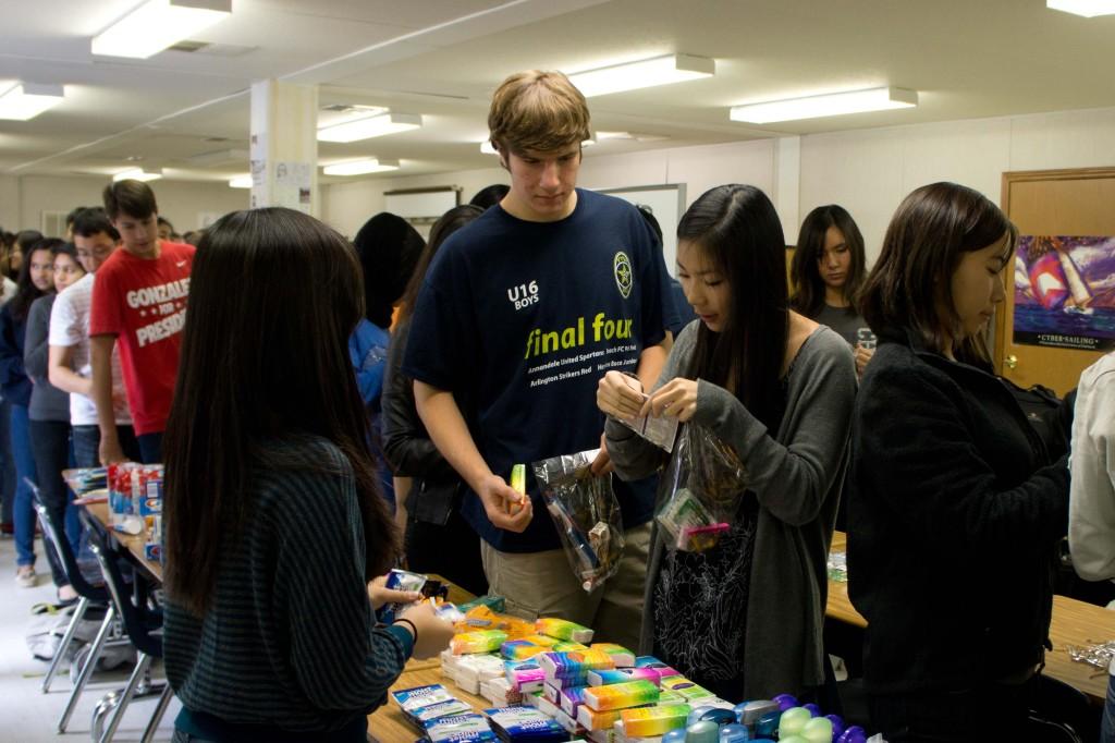 Junior+Seth+Jaffe+and+senior+Florencia+Son+fill+their+care+packages+with+toiletries.