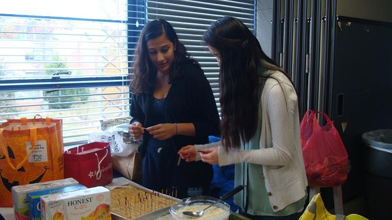 Sophomore Shritika Dahal and junior Melissa Wu prepare for the Hunger Banquet.