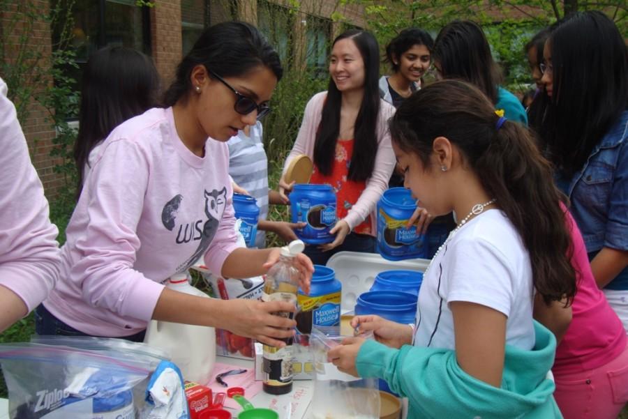 Senior Priya Seetharaman helps a Weyanoke student make an ice cream during an eighth period meeting of Women In Science and Engineering (WISE). 