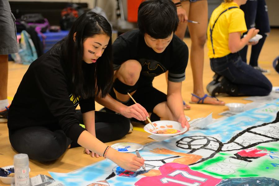 Sophomores Patty Vitsupakorn and Tim Cho work on the Class of 2017's "Back in the Day" banner.