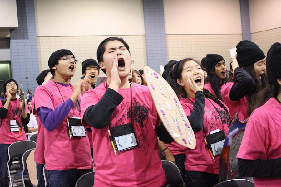 Holding a cardboard shield, junior Junyoung Hwang shout along with his peers during the Spirit Contest.