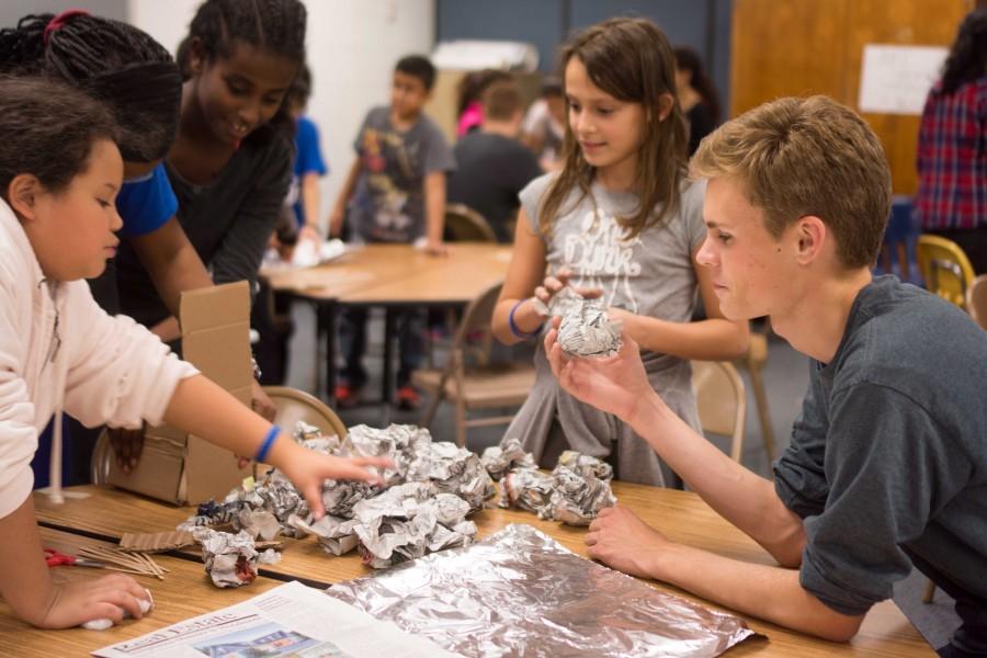 Senior Zane Rossi (right) demonstrates the cushioning effect of newspaper.