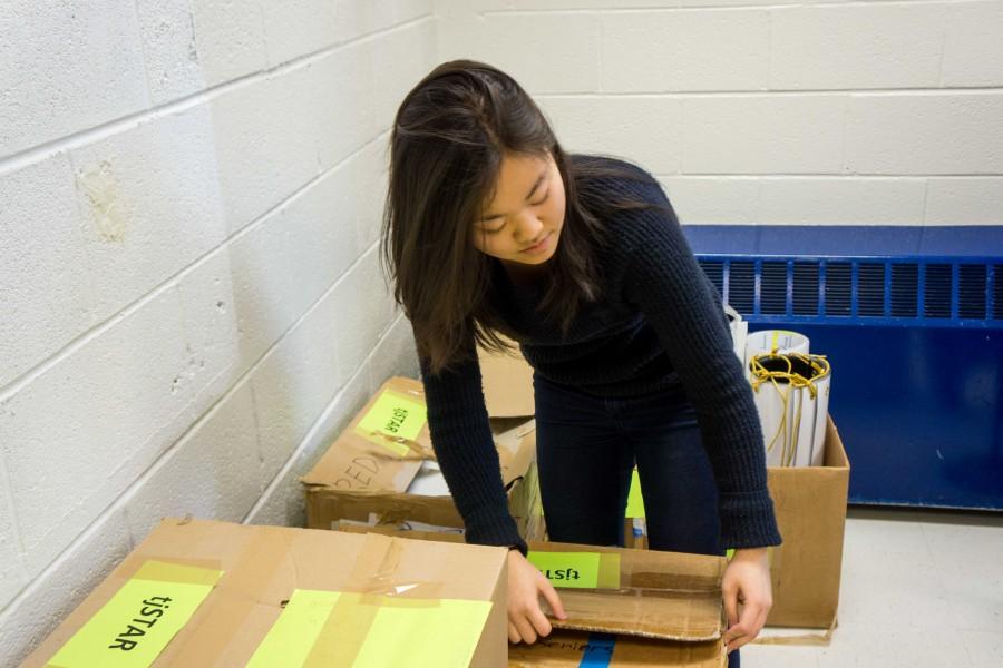 Senior Anna Tsutsui, co-chair of the tjSTAR Planning Committee, conducts an inventory of materials from previous years.