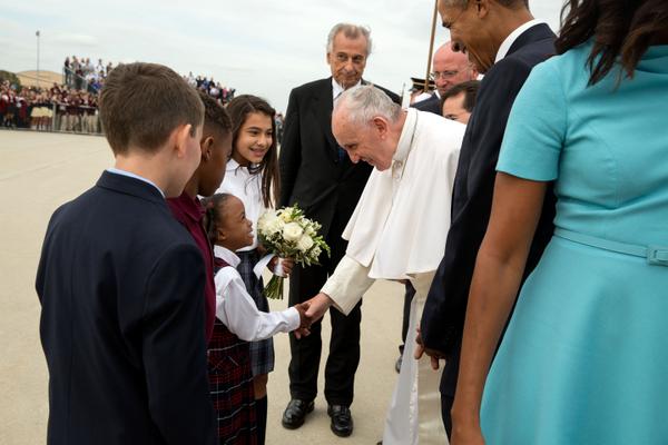 Pope Francis greets children, while President Barack Obama and first lady Michelle Obama look on.