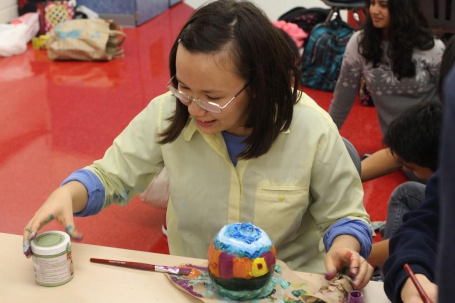 Junior Victoria Bevard grabs more paint to work on her pumpkin