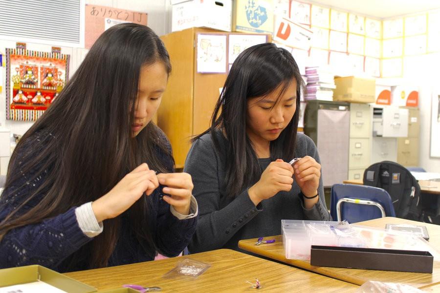 Kim and Jiang create paper crane earrings to sell at Oshōgatsu