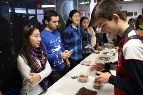 Sophomore Alex Lewis eyes the baked goods at the LIFE bake sale. The bake sale was held on Dec. 16 in the JLounge in order to raise funds.