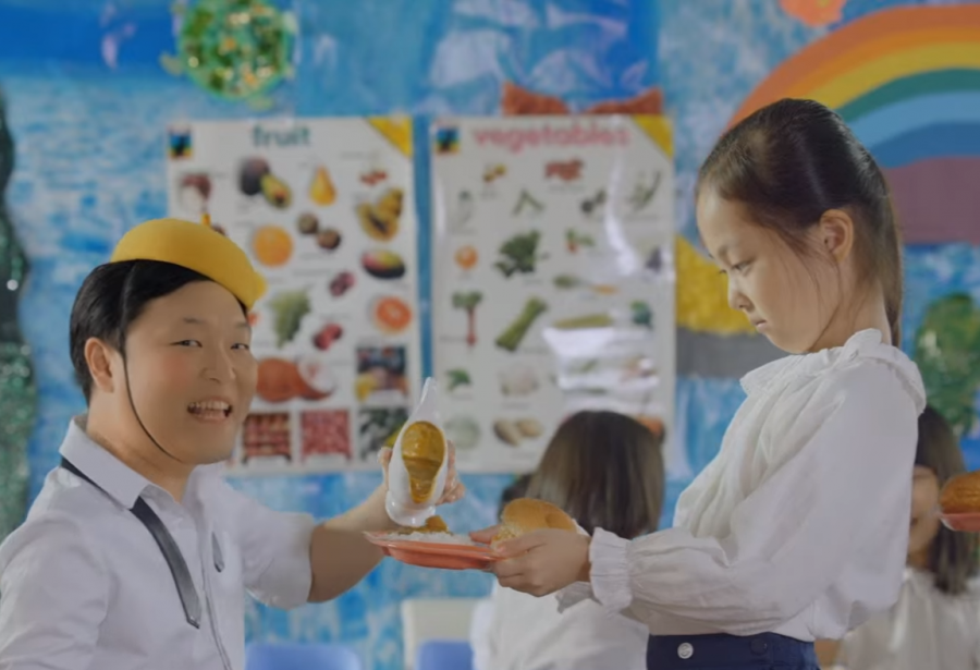 South Korean artist Psy portrays a boy pouring curry onto rice for an adoring girl in his music video for "Daddy."