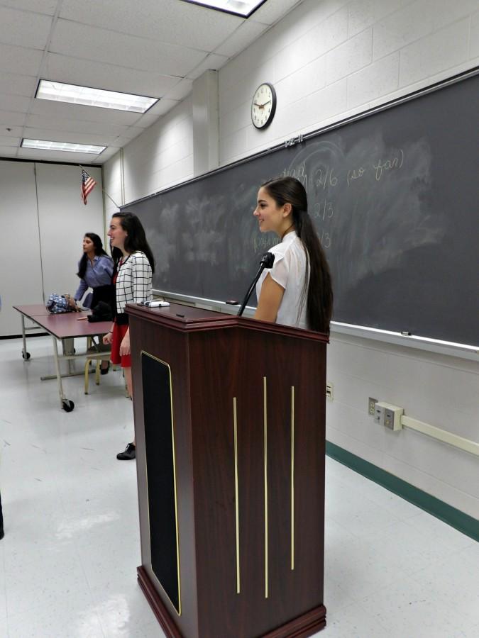 Sophomore Artemis Veizi and sophomore Mara Casebeer talks to the delegates at the podium for the last session of Chantilly Model United Nations Conference.