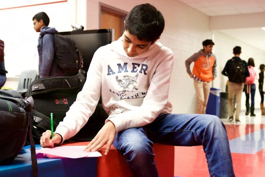 Sophomore Sachit Gupta takes a moment to do some work in a commons area. Like Gupta, many students must use extra time, such as lunches, to finish homework due to their demanding teachers. 