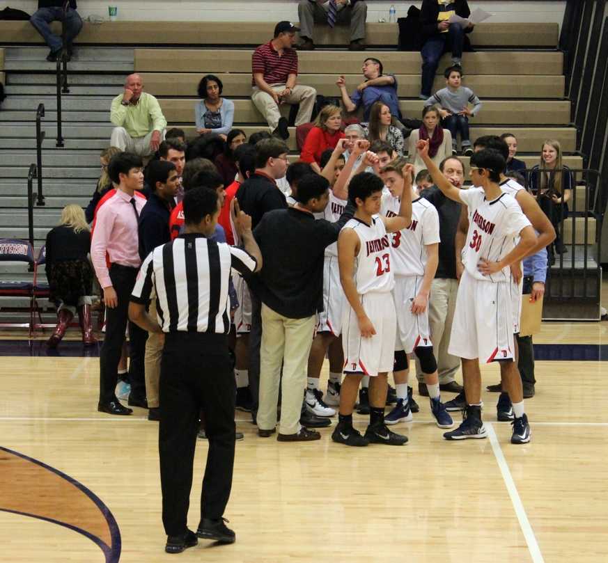 During a time-out, the varsity team ends their strategic huddle with a cheer.