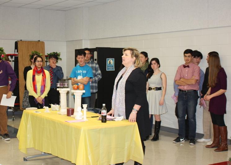 Latin teacher Christine Conklin leads students through the Latin Honor Society Induction Ceremony.  The ceremony took place on Jan. 20 in the cafeteria, and allowed students to journey through their years of the language before Latin Honor Society officers completed the induction.