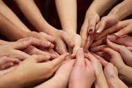 The dance team puts their hands together for good luck before their performance.