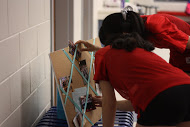 Sophomore Katherine Barbano (left) and senior Andrea Tse (right) get a blast from the past as they look at one of the collages made for the dance team seniors.