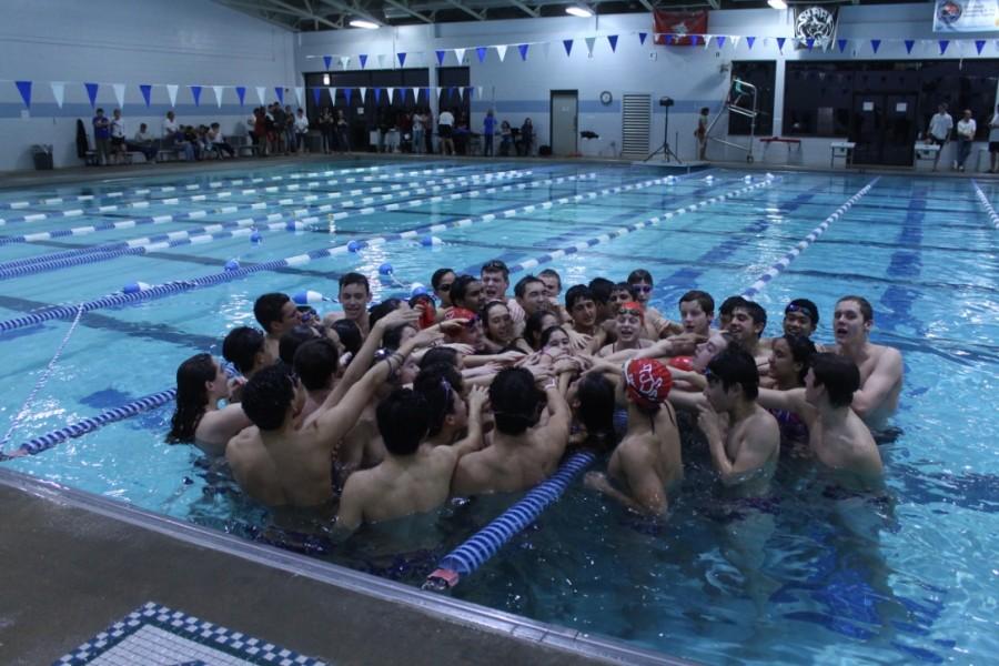 The team puts their hands together before the meet begins.