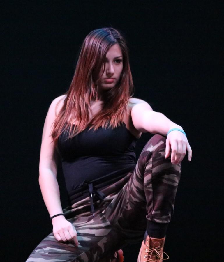 Senior Claire Scoggins strikes a pose as the lights turn on at the start of Black Student Union's (BSU) Hip-Hop performance.