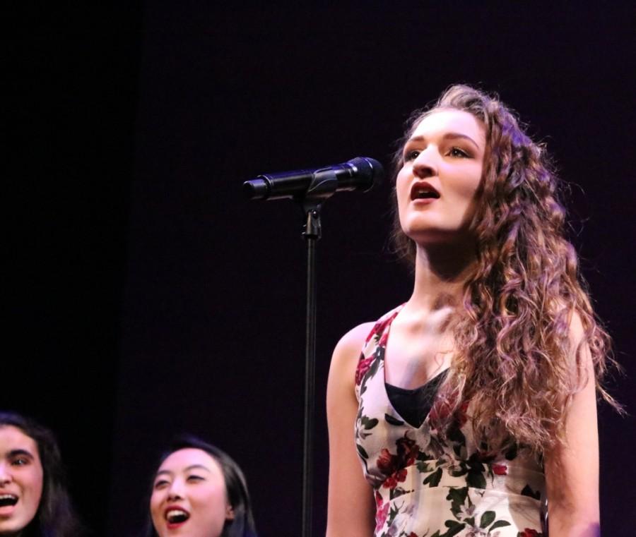 Senior Abbigail Peterson sings the lyrics of Tous les Memes, alongside the rest of Sirens.