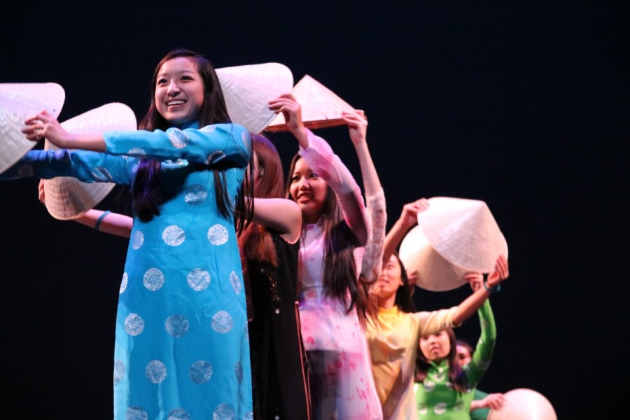 Sophomore Melanie Le and the other performers create a wave with traditional hats for the Japanese Culture Club's performance.