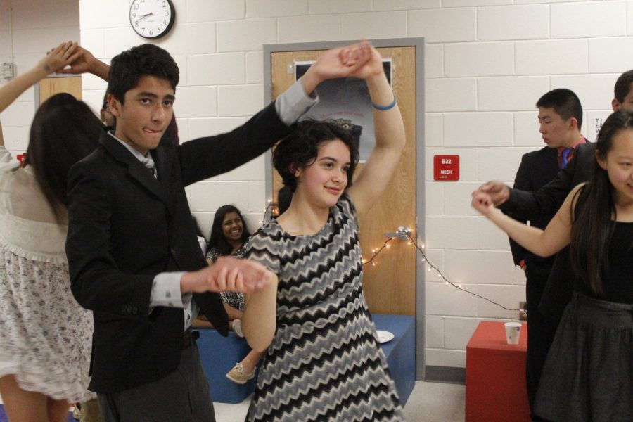 Sophomore Neel Shah watches the dance instructor as he attempts to spin sophomore Maya Parker as taught.