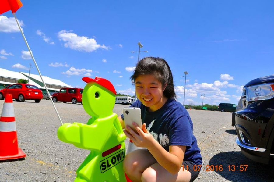 Rising junior Lilian Wang crouches in a parking lot as she spots another Pokémon