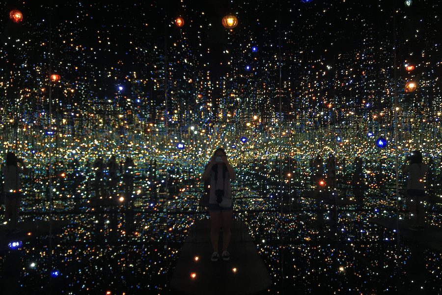 The "Infinity Mirrored Room" by Yayoi Kusama is currently at the Broad. Visitors individually enjoy the installation.