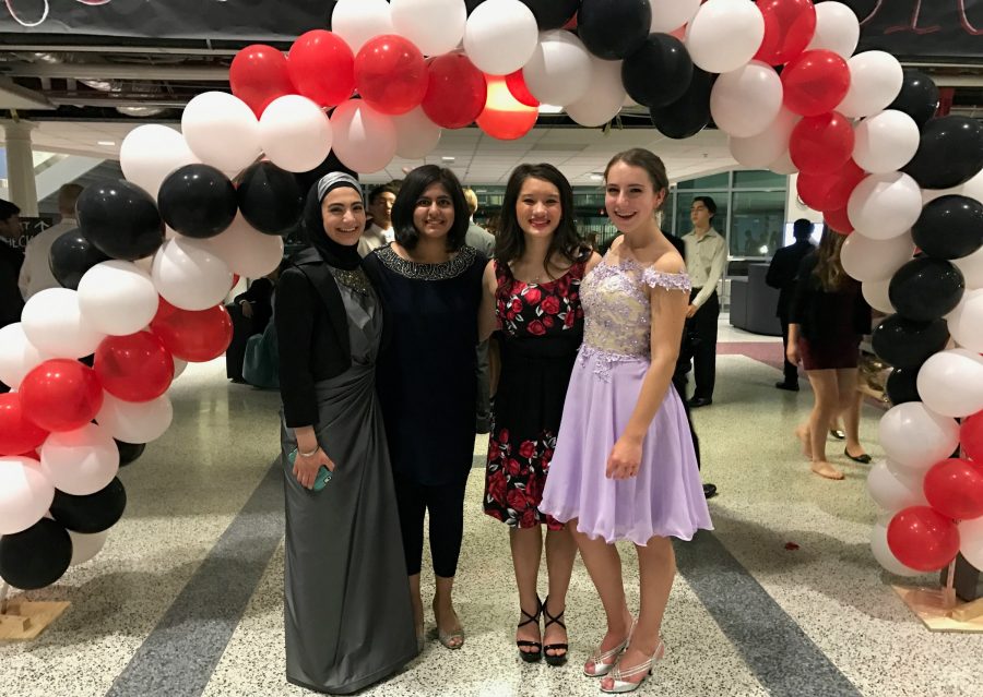 At the dance, students pose in front of the balloon arch for homecoming pictures.