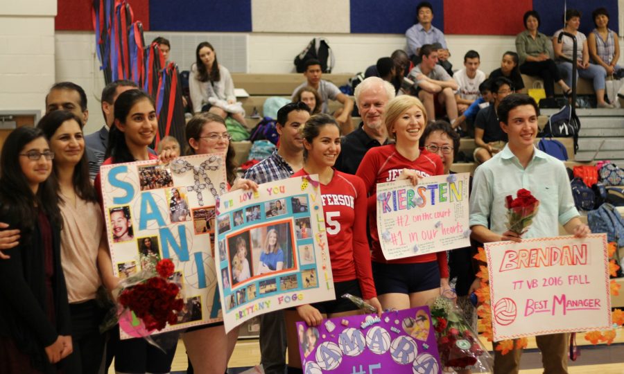 The seniors pose for pictures with the posters their team gave them.