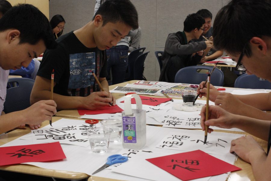 Students practice writing Chinese characters on red paper using Chinese calligraphy brushes in a Chinese Honor Society cultural event. The event took place on Nov. 18 during eighth period. 