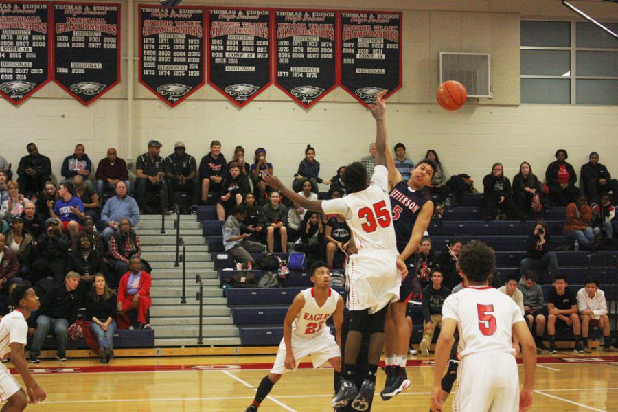 Junior+Noah+Barnes+hits+the+ball+back+on+the+tip-off.