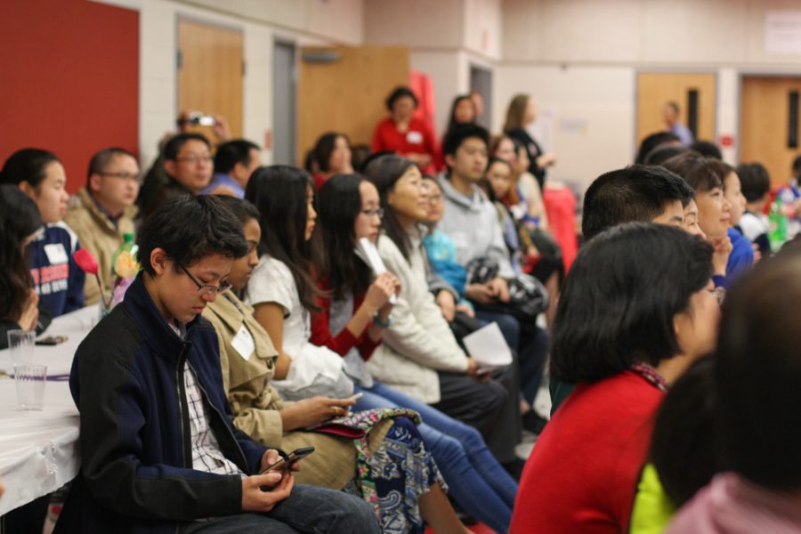 Students and their families listen to speakers. 