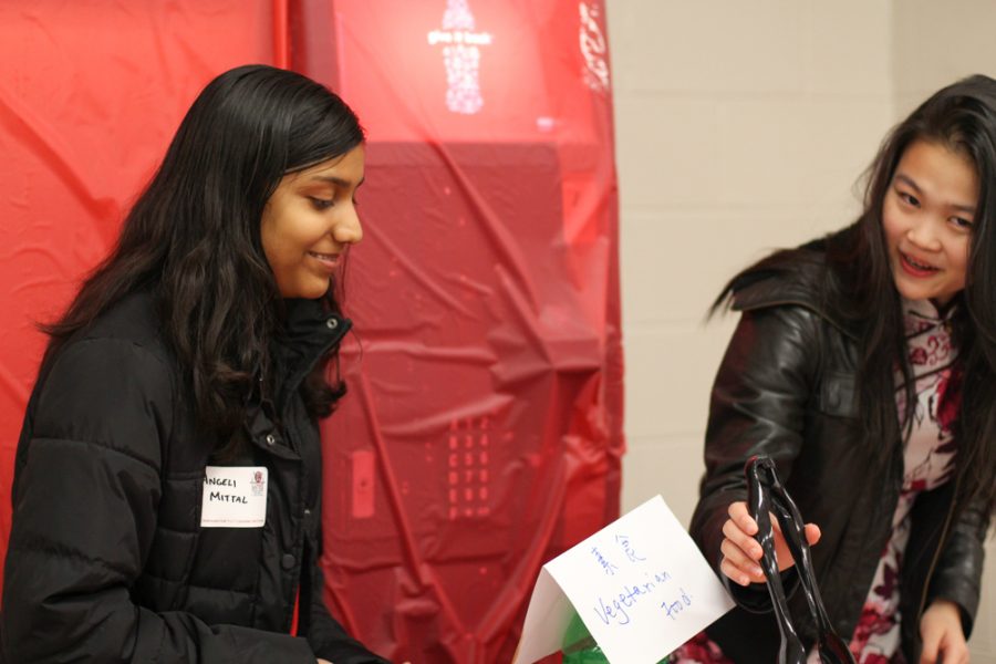 Freshmen Angeli Mittal and Isabelle Deng serve food. 