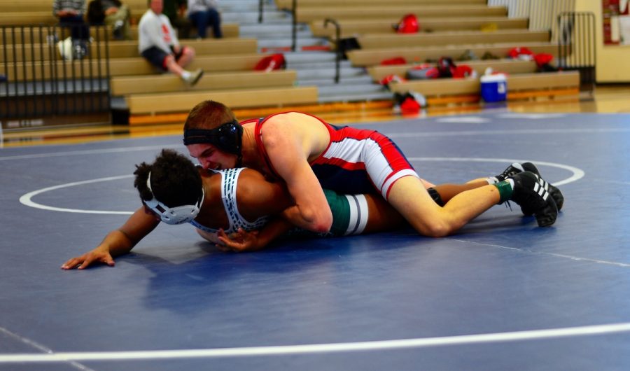 Sophomore Connor Regen pins his Falls Church opponent to the mat.
