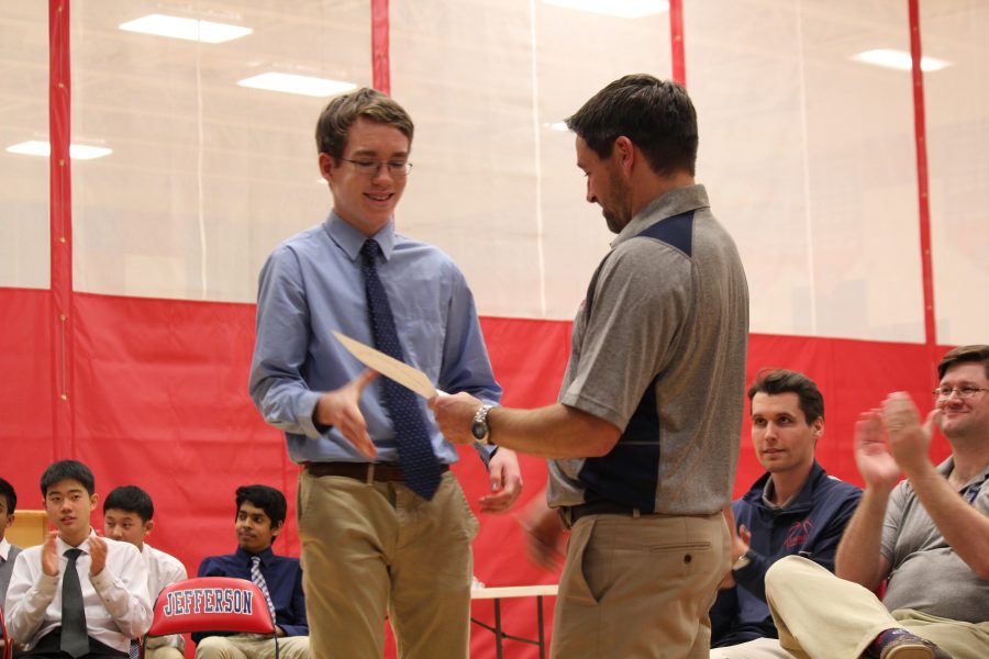 Jake Boltersdorf presents basketball player with a certificate.