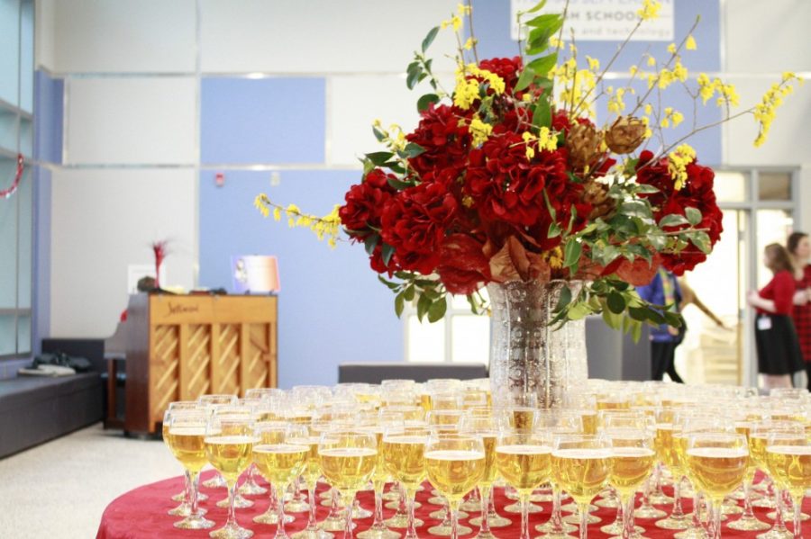A table of drinks surround a bouquet of flowers while music plays in the background.