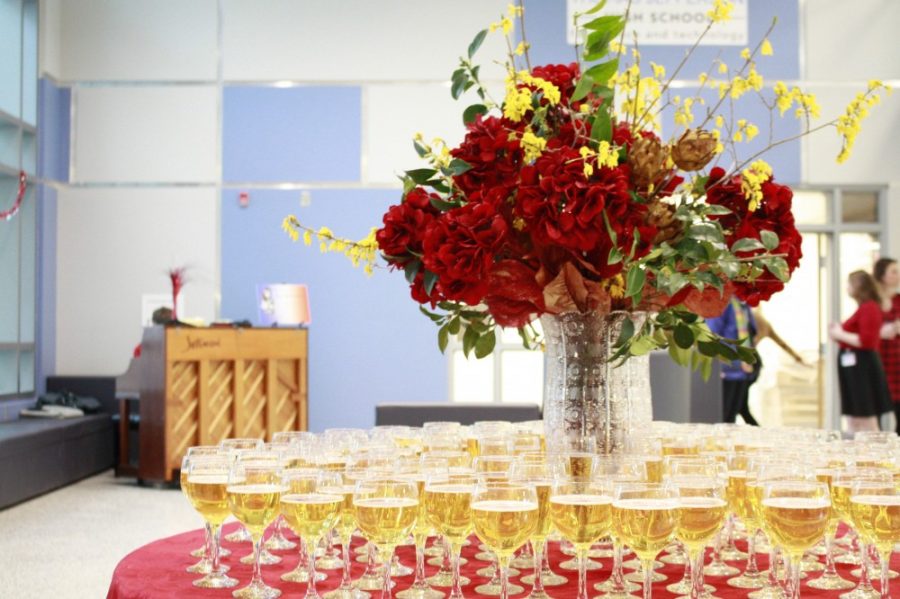 A table of drinks surround a bouquet of flowers while music plays in the background.