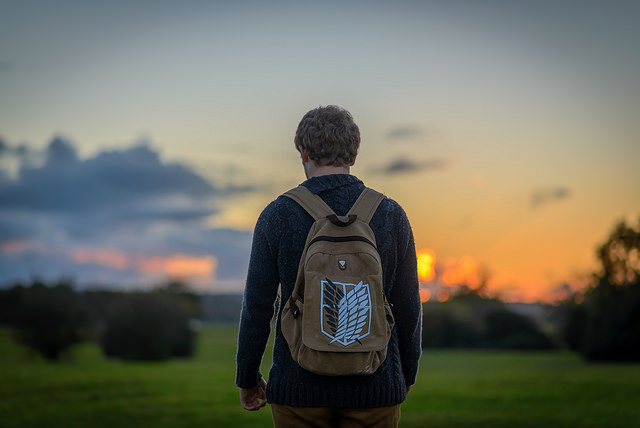 A young man wearing an Attack on Titan backpack. Photo courtesy of Rowan Gillette-Fussell from Flickr.