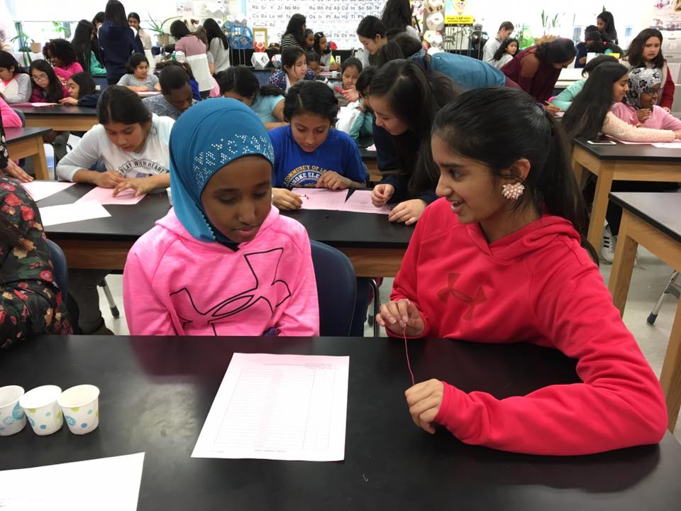 I make a binary bracelet with fifth-grader Bahja Osman during a Women Interested in Science and Engineering (WISE) meeting.  Each color bead on the bracelet represents a different binary digit.