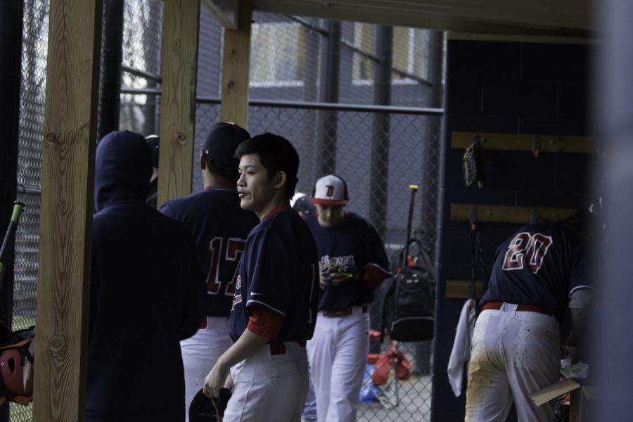 Players watch the game from the dugout.