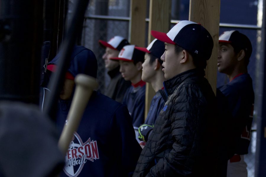 JV baseball team members support players on the field from the dugout during a game on Apr. 7.