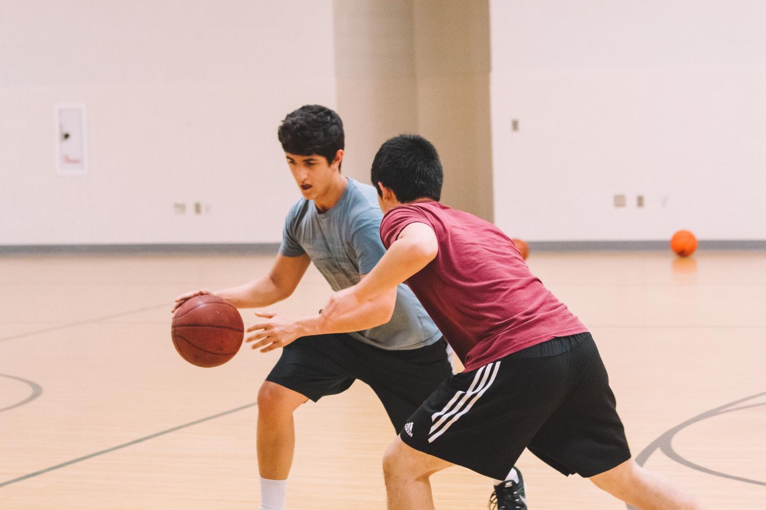 Sophomore Abhishek Bazaz maneuvers around another player while playing an informal game of basketball. 