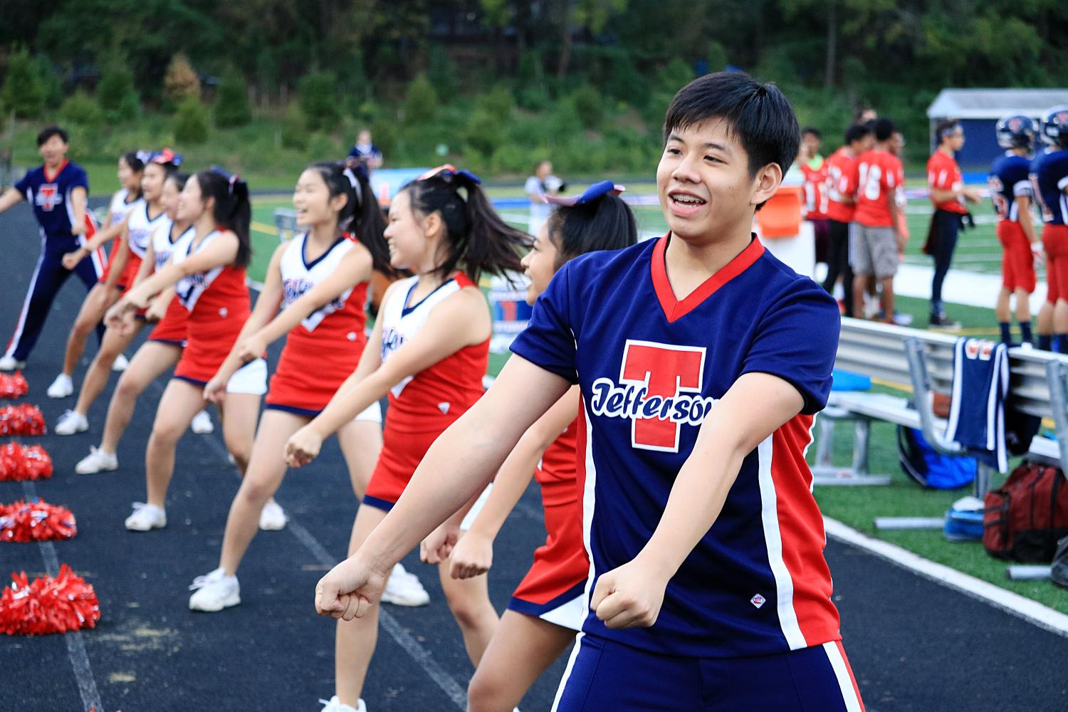 Cheerleader and junior Shawin Vitsupakorn performs cheers in front of the Jefferson crowd alongside other cheerleaders.